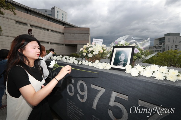 이한열 열사 32주기 추모식이 열린 7일 오후 서울 서대문구 연세대 한열동산에서 재학생들이 헌화하고 있다.