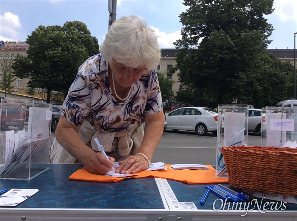 한 헝가리 할머니가 유람선 사고를 애도하는 메시지를 적고 있다. 