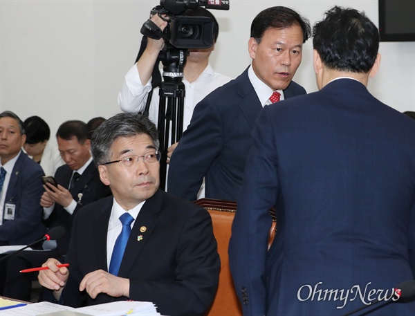 자유한국당 윤한홍 의원이 10일 오전 국회에서 열린 사법개혁 특별위원회 전체회의에서 개회 반대 의사를 밝힌뒤 퇴장하다 김오수 법무부 차관과 인사하고 있다. 왼쪽 아래는 민갑룡 경찰청장. 