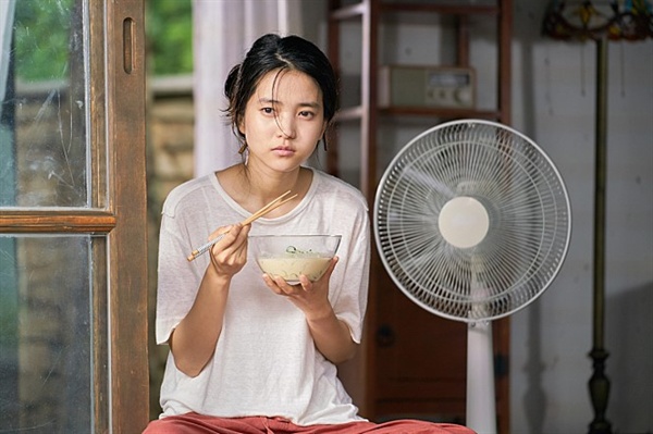  영화 <리틀 포레스트> 스틸. 마루에 앉아 시원한 콩국수를 먹고 있는 혜원(김태리)의 모습