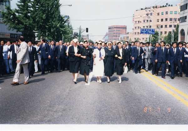  1987년 이한일 열사 장례식 날 거리행진 중인 이희호 여사. 이태영 선생과 함께 걸었다. 가운데 흰옷이 이희호 여사. 