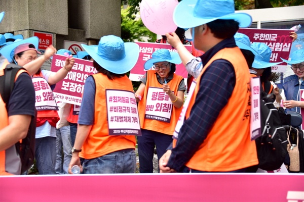 노동청 앞에서 '최저임금 개악, 노동조합 탄압' 등의 문구가 적힌 풍선을 터트리며 환호하는 참가자들
