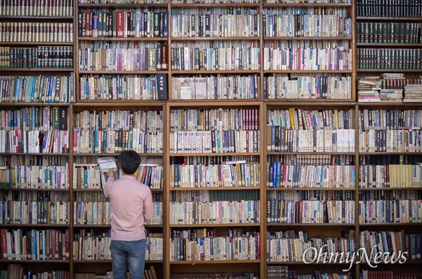 책마을 해리 이대건 대표의 키보다 훨씬 높은 책장에 책들이 가득 들어차 있다. 