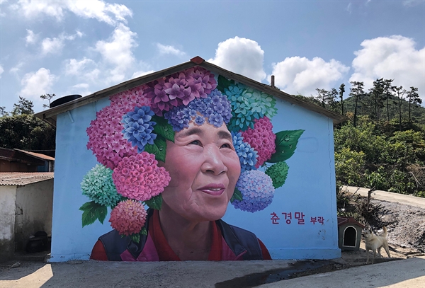 이세돌 기사의 어머니 박양례씨도 자신이 나고 자란 고향집 마을벽화의 모델이 되었다. 수국꽃 화환을 쓴 어머니의 미소가 그윽하다.