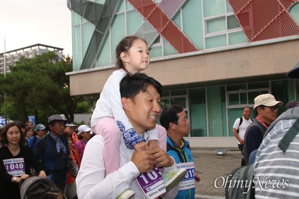 15일 진행된 평화통일염원 걷기대회에서 어린이를 무등에 태운 한 참가자가 걸음을 옮기고 있다.