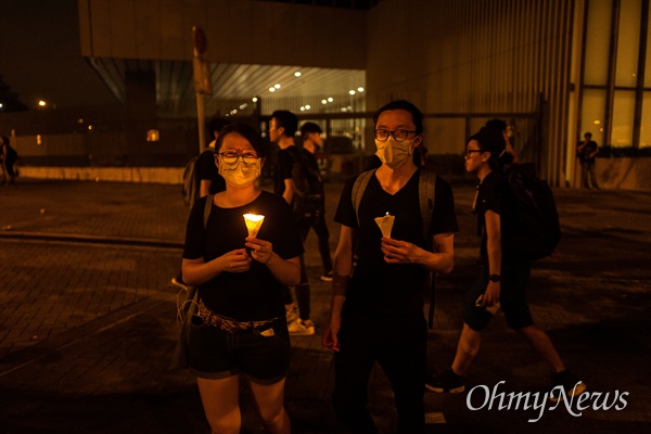  17일 오전 ‘검은 행진’에 참가한 홍콩 시민들이 행진을 마치고 중앙정부청사 주변에 촛불을 밝히고 있다.