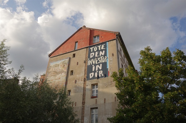 "너 안의 투자자를 죽여라."라는 문구가 써져있는 베를린의 건물벽.