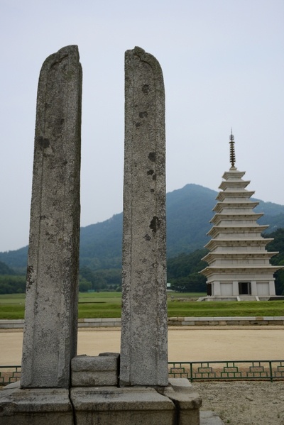 동당간 지주  불교행사 때 기를 거는 장대를 받혀 주는 역할을 한다. 뒤에 보이는 것이 9층 석탑이다.