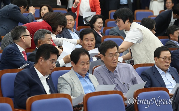 여야3당 원내대표가 국회 정상화에 최종 합의한 24일 오후 서울 여의도 국회에서 열린 자유한국당 의원총회에 참석한 의원들이 합의문을 보고 있다.