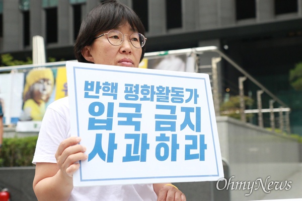 26일, AWC 한국위원회 이경자 운영위원이 서울 종로구 일본대사관 앞에서 ‘반핵 평화활동가 입국 금지 사과하라’라는 손팻말을 들고 일본 정부에 항의했다.