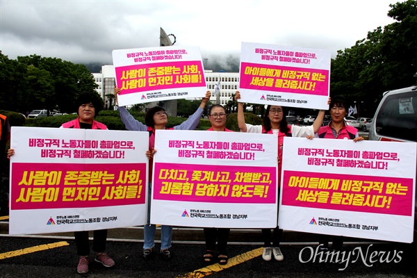 전국학교비정규직노동조합 경남지부 간부들이 '총파업'을 앞둔 6월 27일 경남도청 정문 앞에서 손팻말을 들고 서 있다.