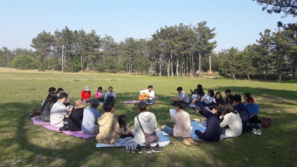 신안군 도초도 시목해변 해송밭에서 섬마을 인생학교 참가자들이 '작은 음악회' 프로그램에 참여하고 있다.
