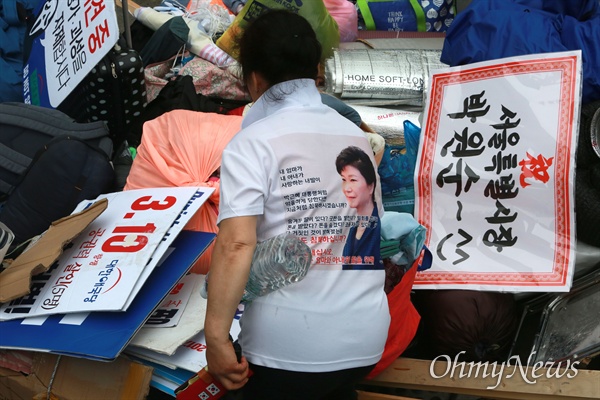 박근혜 전 대통령 티셔츠를 입은 우리공화당원이 농성장 물건을 정리하고 있다.