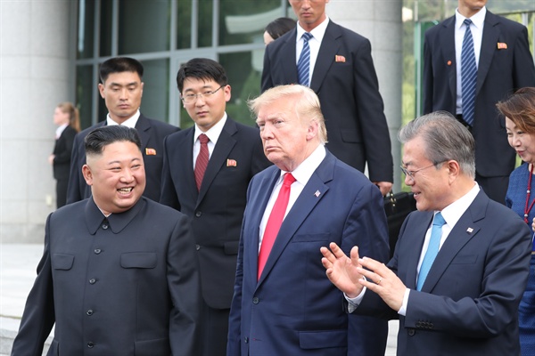 도널드 트럼프 미국 대통령, 김정은 북한 국무위원장이 2019년 6월 30일 오후 판문점 남측 자유의 집에서 회동을 마친 뒤 문재인 대통령과 함께 군사분계선으로 이동하고 있다.