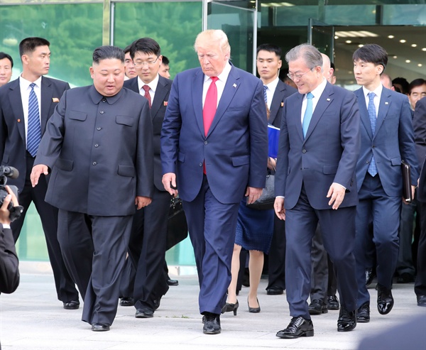 도널드 트럼프 미국 대통령, 김정은 북한 국무위원장이 30일 오후 판문점 남측 자유의 집에서 회동을 마친 뒤 문재인 대통령과 함께 군사분계선으로 이동하고 있다.