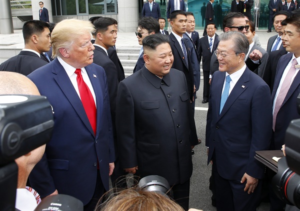 문재인 대통령(오른쪽부터), 북한 김정은 국무위원장, 미국 도널드 트럼프 대통령이 30일 오후 판문점 남측 자유의 집 앞에서 만나 얘기를 나누고 있다.