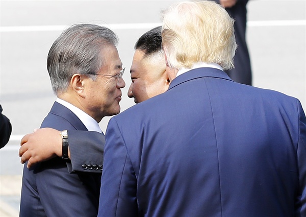 문재인 대통령이 6월 30일 오후 판문점에서 도널드 트럼프 미국 대통령(오른쪽)과 만난 뒤 북으로 돌아가는 김정은 국무위원장을 포옹으로 배웅하고 있다. 
