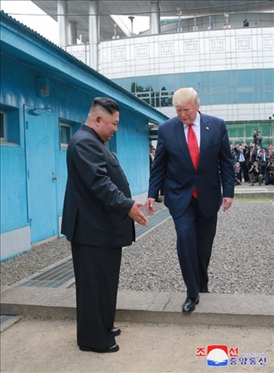 김정은 북한 국무위원장과 도널드 트럼프 미국 대통령이 6월 30일 판문점에서 만났다고 조선중앙통신이 1일 보도했다. 사진은 중앙통신이 홈페이지에 공개한 것으로, 김정은 국무위원장이 군사분계선(MDL) 북측으로 트럼프 대통령이 넘어오도록 손짓으로 안내하고 있다. 