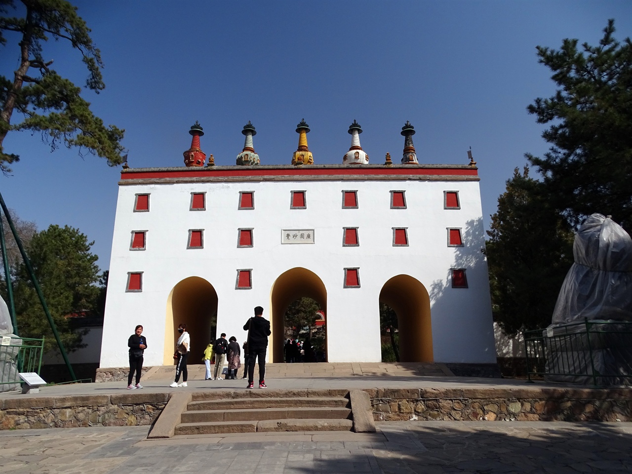 세 개의 아치형 문이 있는 티베트식 흰 건물 위에 다섯 개의 탑이 세워져 있어 오탑문이라 한다.