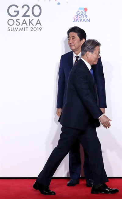 문재인 대통령이 지난 6월 28일 오전 인텍스 오사카에서 열린 G20 정상회의 공식환영식에서 의장국인 일본 아베 신조 총리와 악수한 뒤 이동하고 있다.