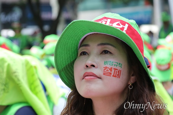 4일 오후 대구시교육청 앞에서 학교비정규직 노조 조합원들이 집회를 연 가운데 한 조합원이 비정규직 철폐를 얼굴에 쓰고 앉아 있다.