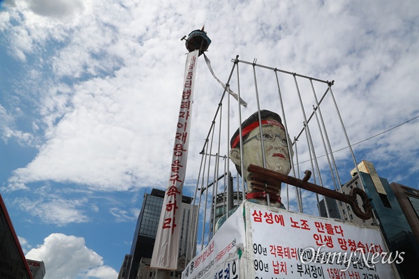 삼성해고자 김용희씨가 고공농성장 아래에 이재용 부회장 모형이 놓여 있다.
