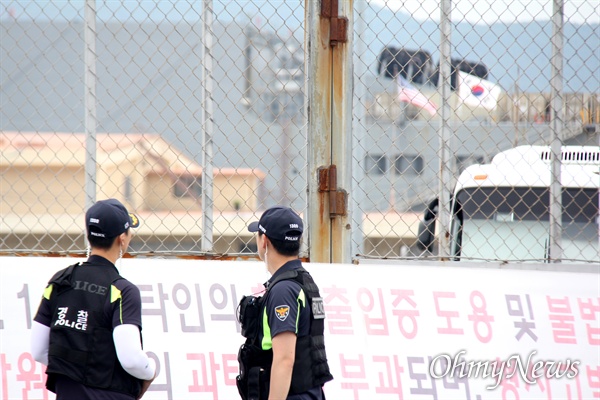 부산항 8부두에 있는 미군부대 세균무기실험실로 추정되는 시설물(태극기, 성조기 매달려 있는 건물) 앞에 경찰이 서 있다.