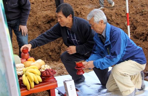 ‘홍성 광천면 담산리 폐광산’에서 부친을 잃은 유가족 이종민(왼쪽)씨와 최홍이(오른쪽)씨가 지난 2015년 11월, 유해매장지 앞에서 절을 올리고 있다
