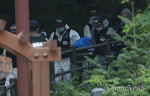 16일 오후 서울 서대문구 한 산에서 정두언 전 국회의원이 숨진 채 발견된 가운데, 과학수사 대원들이 시신을 수습한 뒤 차량으로 이동하고 있다.