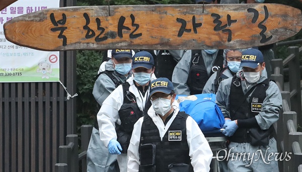 16일 오후 서울 서대문구 한 산에서 정두언 전 국회의원이 숨진 채 발견된 가운데, 과학수사 대원들이 시신을 수습한 뒤 차량으로 이동하고 있다.