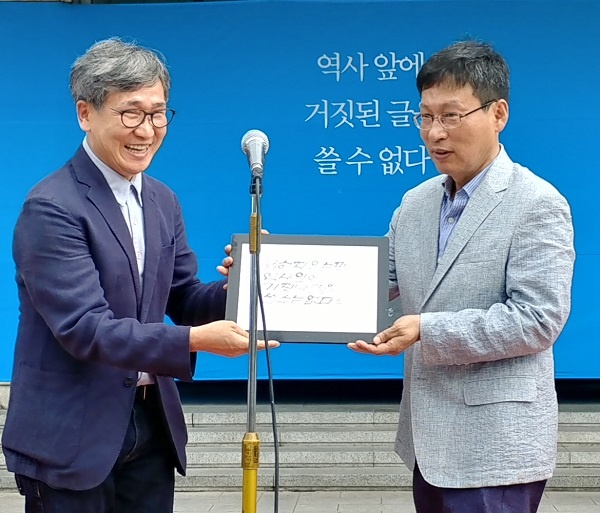 소설가 이외수 작가가 목저체로 쓴 작품이 조형물 건립에 혼신을 쏟은 김환균 전 언론노조위원장에게 전달됐다.