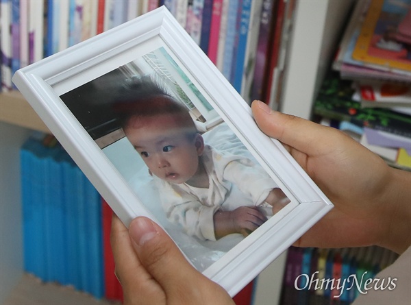 서울랜드 경사진 주차장에서 미끄러진 SUV 차량에 머리를 부딪혀 아들 잃은 고 최하준 군 어머니 고유미씨가 아들의 사진을 보고 있다. 