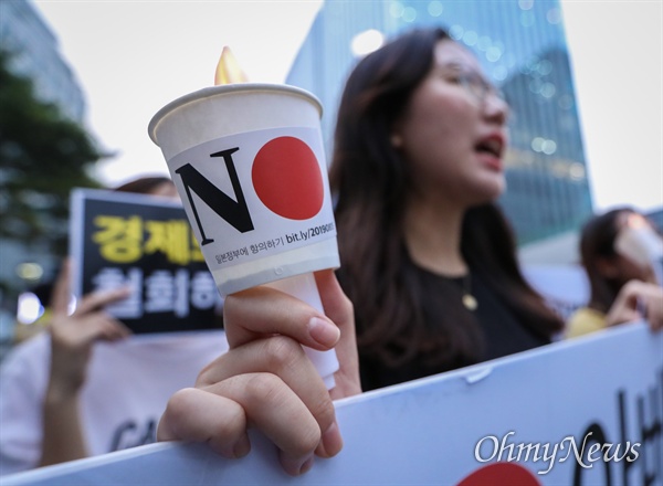 겨레하나 회원들이 18일 오후 서울 종로구 일본대사관 앞에서 일본의 경제보복조치에 대한 규탄 촛불집회를 열고 아베 규탄과 ‘친일적폐’ 반대를 주장하고 있다.