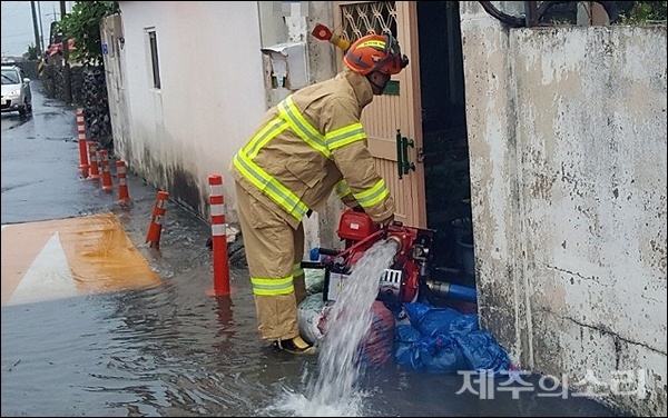 19일 오전 6시쯤 제주시 내도동의 한 주택이 침수돼 119대원들이 배수 작업을 벌이고 있다. [사진제공-제주소방서]