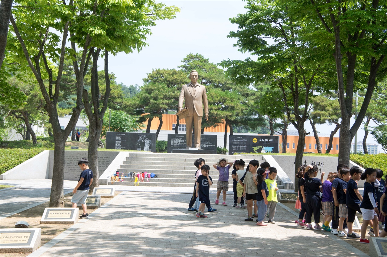 박정희 동상 앞 계단에 짐을 모아놓고 유치원 어린이들이 선생님 앞으로 모이고 있다. 이들은 박정희를 어떻게 기억하게 될까.