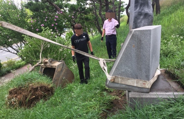 지난 24일, 대전 대덕구(구청장 박정현) 관계자가 대덕구 무궁화동산에 있는 계룡건설 고 이인구 전 명예회장(전 국회의원) 조부의 독립운동 행적을 담은 공적비(앞쪽)와 기념비(뒷쪽)를 철거하고 있다.