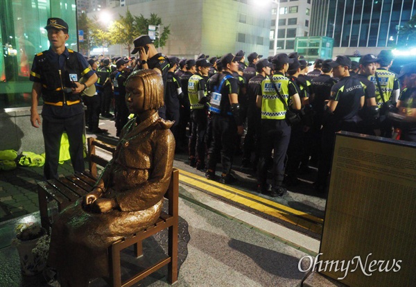  적폐청산사회대개혁 부산운동본부가 7월 27일 저녁 일본총영사관 앞 도로에서 거리행진 뒤 마무리 집회를 여는 동안 경찰이 배치되어 있다.