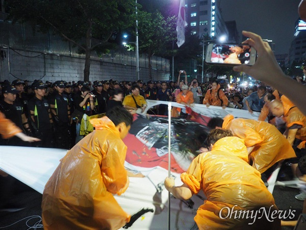 적폐청산사회대개혁 부산운동본부는 7월 27일 저녁 일본총영사관 앞에서 집회를 벌이며 아베 총리의 얼굴이 그려민 대형 펼침막에 페인트 세례를 가했다.