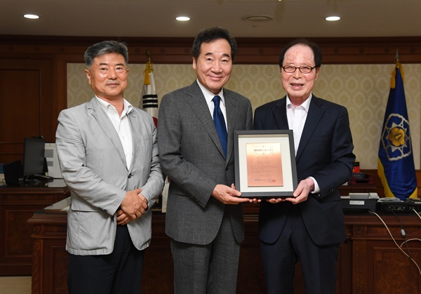 권영길 평화철도 이사장이 30일 이낙연 총리한테 '평화철도 침목 기증 인증서’를 전달했다.