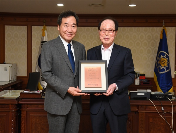 권영길 평화철도 이사장이 30일 이낙연 총리한테 '평화철도 침목 기증 인증서’를 전달했다.