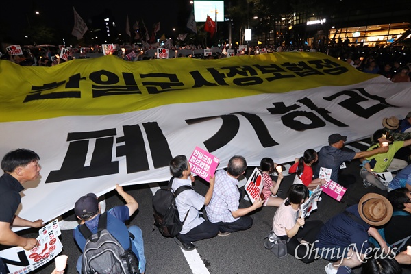 3일 오후 서울 종로구 일본대사관 앞에서 아베규탄 시민행동 주최로 열린 '역사왜곡, 경제침략, 평화위협 아베정권 규탄 3차 촛불문화제'에서 참가자들이 행진하며 대형현수막을 펼쳐보이고 있다.