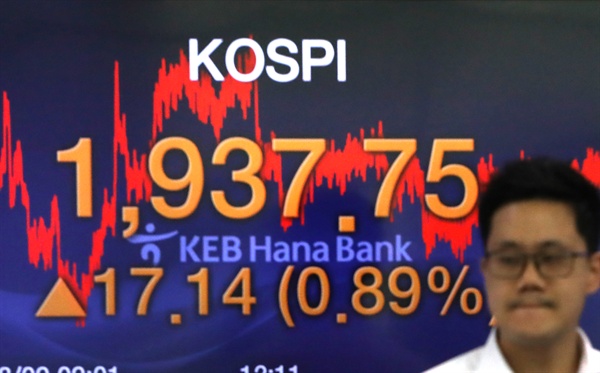 코스피가 17.14포인트 오른 1,937.75로 장을 마감한 9일 오후 서울 중구 KEB 하나은행 딜링룸에서 한 딜러가 전광판 앞을 지나고 있다.