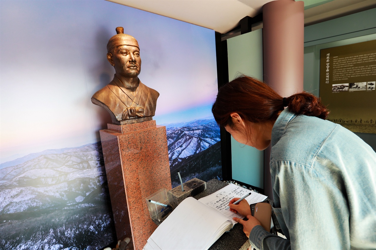 신돌석 장군 유적지를 찾은 관광객이 방명록을 작성하고 있다.