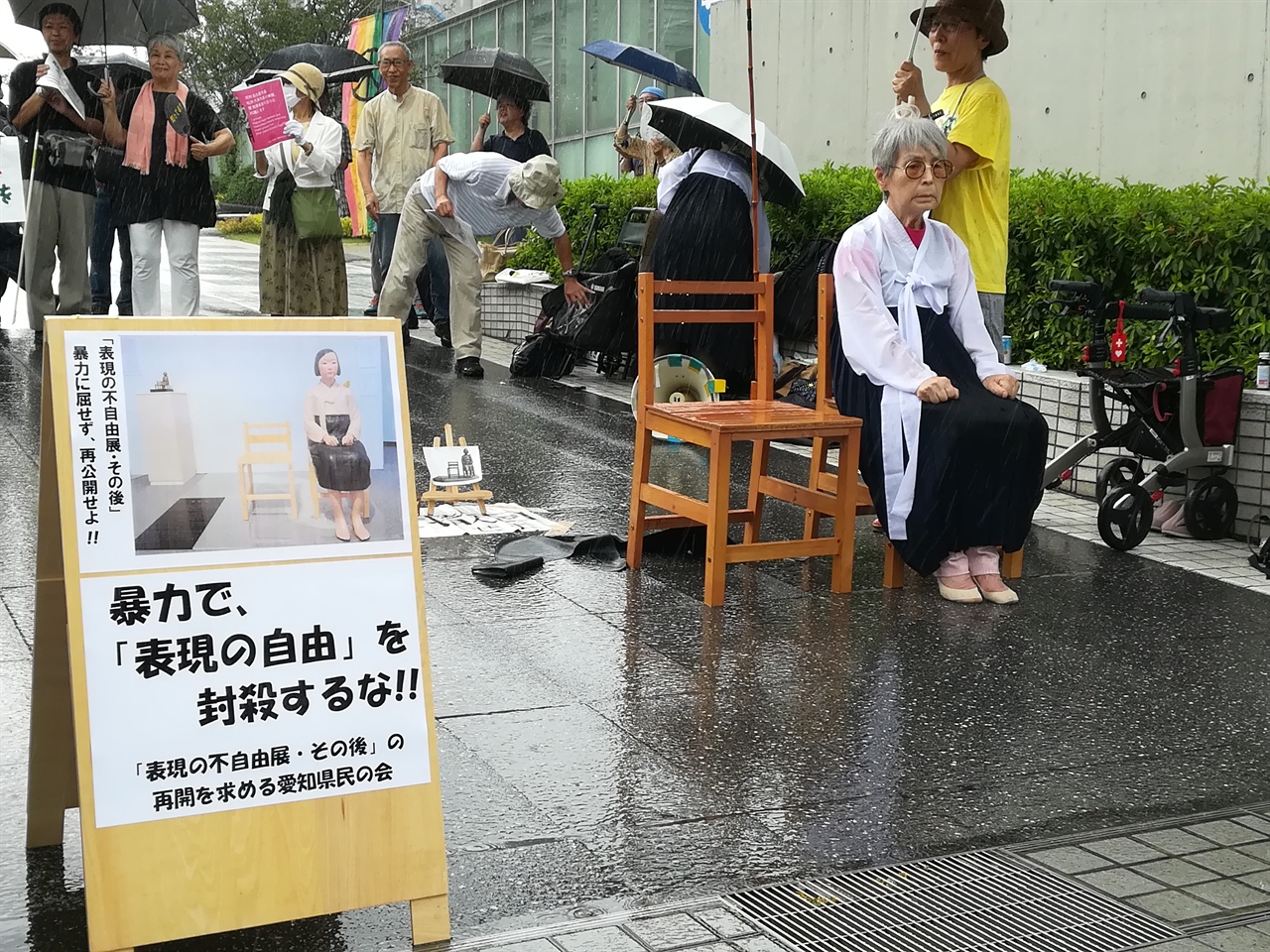 갑자기 쏟아진 폭우에도 '소녀상'의 자리를 지키는 니시 에이코씨.