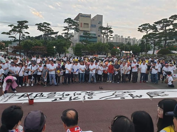 이날 걷기대회에 앞서？ 광복의 기쁨과 함께 일본의 경제침략에 단호하게 대처하겠다는 의지의 표현으로 '역경을 이기고 핀 꽃이 아름답다'라고 쓰인 붓글씨 퍼포먼스가 이어졌다.