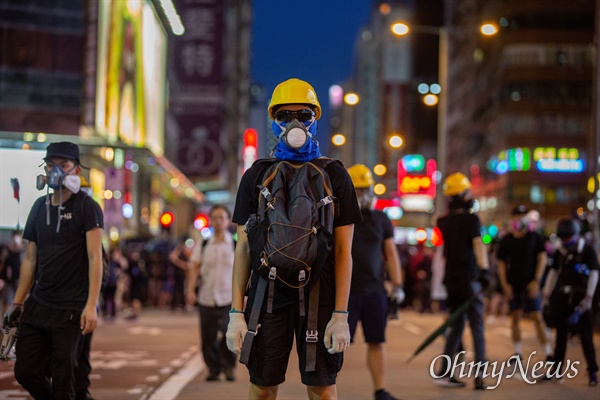 2019년 8월 7일 오후 홍콩 몽콕 경찰서 주변에서 송환법 반대 시위 참가자들이 경찰과 대치하던 중 최루탄에 대비해 방독면을 쓰고 있는 모습. 