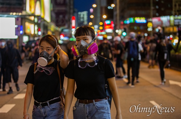 17일 오후 홍콩 몽콕 경찰서 주변에서 송환법 반대 시위 참가자들이 경찰과 대치하던 중 최루탄에 대비해 방독면을 쓰고 있다. 