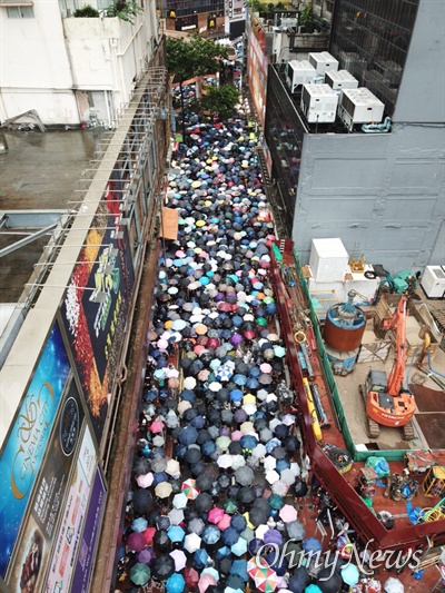 우산을 든 홍콩시민들이 좁은 골목길을 통해 거리로 쏟아져 나가고 있다.