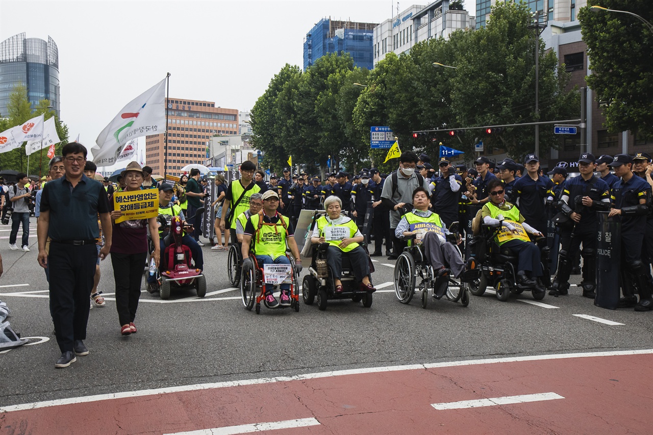 장애등급제 폐지를 외치며 행진하고 있다