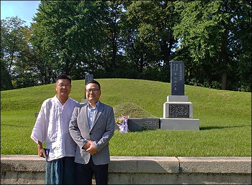 외할아버지 차리석 선생과 외할머니 강리성 여사가 합장되어 있는 무덤 앞에 선 유기수(왼쪽), 유기방 외손자